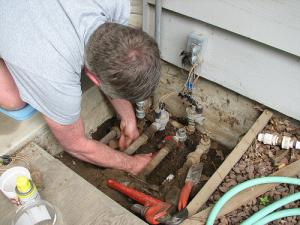 checking the main line hookup during a routine sprinkler repair in Tacoma, Washington