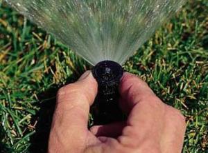 a contractor is adjusting the sprinkler head